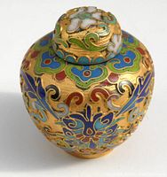 Top angled view of the small cloisonne jar showing detailed colorful patterns on gold background and the lid on top.