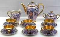 Vintage tea and coffee service set with purple black and white marbled porcelain and gold interior, including teapot, sugar bowl, creamer, cups and saucers.
