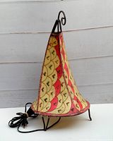 Side angle of the vintage Moroccan rawhide lamp with henna design and wrought iron frame.