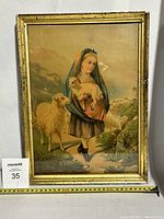 Framed antique lithograph showing a young girl holding a lamb, standing beside an adult sheep outdoors.