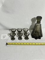 Full set of one decanter with stopper and six matching glasses with measuring tape for scale
