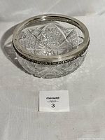 Top-down view of the clear cut crystal bowl with silver rim, showing the detailed geometric pattern on the glass and the silver border.