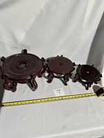 Three wooden Asian Chinese style plant pot/vase stands in graduated sizes with measuring tape visible.