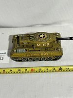 Full side view of the vintage M-56 General tank toy with measuring tape showing approx 14 inches in length.