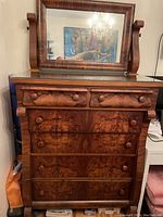 Full view of the vintage flamed mahogany dresser with glass top and attached mirror.