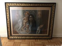 Frontal view of the pastel painting with woman and child in ornate black and gold frame.