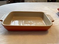 Top-down view showing the interior and rectangular shape of the orange Le Creuset casserole dish with handles.