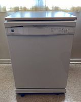 Front view of the Kenmore dishwasher showing the white exterior with control panel and handle.