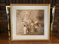Frontal image of the still-life photo showing two white and cream flower arrangements in two ceramic vases on a neutral background, enclosed in gold-coloured frame with white matting.