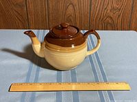 Teapot placed horizontally next to a 12-inch ruler showing size and shape.
