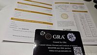 Photo of GRA certification card for moissanite gemstone showing authenticity and warranty information.
