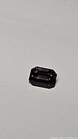 Rectangular emerald-cut purple spinel on white background