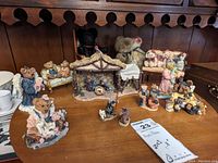 Photo shows all figurines and plush bears arranged on wooden lazy Susan on top of a wooden cabinet, bears in front and back, nativity stable center back