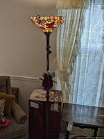 Full view of floor lamp with butterfly shade and attached fairy ornament