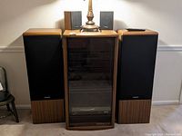 Full system with wooden cabinet and floor speakers under a lamp