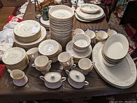 Full table arrangement showing all dish types stacked and grouped, including plates, cups, bowls, platters, sugar bowls, and creamer in Lenox Special pattern.