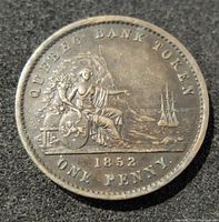 Obverse side of 1852 Quebec Bank One Penny Token displaying a seated female figure with ship and coastline, dated 1852.