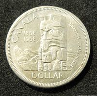 Obverse side of the 1958 Canada silver dollar coin showing the totem pole and British Columbia commemorative design.