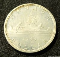 Close up of the front side of the coin showing the canoe design and the year 1966.