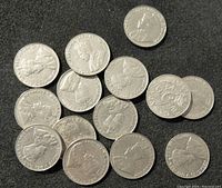 Top view of a pile of various old Canadian 5 cents coins showing King George VI portrait obverse side