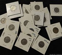 Several old Canadian 5 cents coins mounted individually in white cardboard holders with handwritten years including 1940, 1946, 1947, 1953, and others.