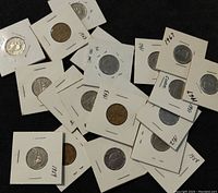 Various old Canadian 5 cents coins individually mounted in cardboard holders with handwritten years visible.