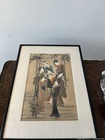 Framed Japanese woodblock print with geishas in bamboo setting, full view.