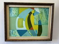 Frontal view of framed abstract painting with green, blue, yellow, orange geometric shapes against white wall
