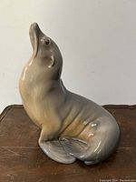 Front-angle view of the ceramic sea lion figurine, showing glossy finish and detailed facial features.