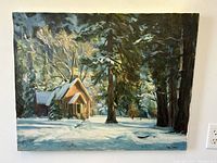 Front view of the signed oil painting on canvas showing a winter chapel scene at twilight with snow and trees.