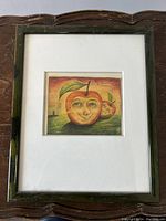 Frontal view of framed artwork showing white mat and dark green mottled wooden frame.