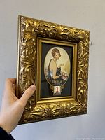 Gilt wood frame held by hand showing front view and overall size
