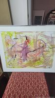 Full view of framed abstract watercolor painting with fluid brush strokes and color details.