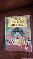 Front cover of the comic book showing Tintin with two guards and Snowy at a castle gate, titled 'Le Sceptre d'Ottokar'.