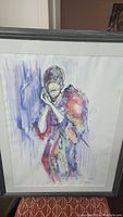 Framed original signed artwork showing full piece with figure in colorful clothes and large head covering.
