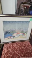 Framed abstract watercolor painting featuring an abstract reclining figure in a muted color palette, signed in the corner.