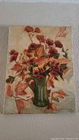 Photo of full oil painting on canvas showing flowers in a green vase with red-orange blooms and leaves on a muted background.