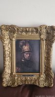 Photo of vintage canvas print portrait of a man in an ornate, detailed gold-colored baroque frame.