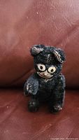 Front view of vintage black cat toy showing detachable head and worn black fabric.
