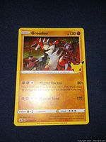 Close-up photo of Groudon foil Pokemon card featuring the character and moves.