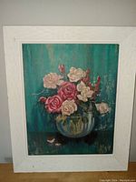 Framed oil on board floral painting featuring pink and white roses in glass bowl, teal background with signs of paint peeling.
