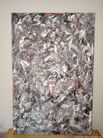 Front view of large abstract painting on canvas, showing overall composition of greys, black and red brush strokes.