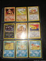 Photo of 9 Pokemon cards front sides in a binder sheet, showcasing characters Growlithe, Marowak, Pidgey, Misdreavus, Muk, Diglett, Persian, Staryu, Swanna, Krabby.