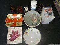 Top view of the collection showing bowls, jugs, decorative dish, tile, and card pack