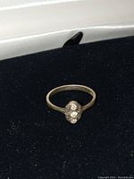 Front view of the ring showing three diamonds set in a cluster on a thin sterling silver band.