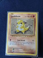 Front of Sandshrew Pokemon card showing the artwork, HP, move and stats in good condition.