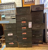 Stack of green metal storage drawers in workshop setting