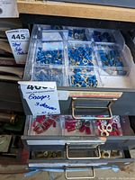 Top drawer showing blue insulated ring and spade wire terminal connectors organized in clear plastic trays.