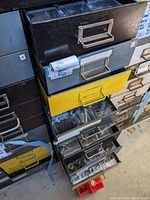Stacked file cabinet fronts showing various drawer pulls in metal and painted finishes