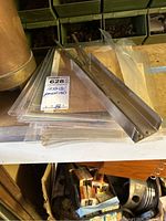 Plastic sleeve protected stack of papers and metal binder clamp on a surface with some packs in the background